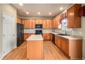 Kitchen with light wood cabinets, an island, and hardwood floors at 4050 S Odessa St, Aurora, CO 80013