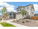 Beige two-story house with stone facade and landscaping at 13332 E 110Th Way, Commerce City, CO 80022