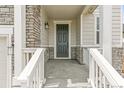 Covered front porch with gray door and white railings at 13332 E 110Th Way, Commerce City, CO 80022