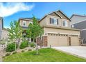 Two-story house with tan siding, stone accents, and a two-car garage at 5878 Berry Ridge Way, Castle Rock, CO 80104