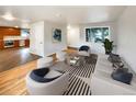 Open living room with hardwood floors and view into kitchen at 123 Emerald St, Broomfield, CO 80020