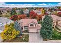 Two-story house with brown roof and autumn trees in the neighborhood at 9688 Colinade Dr, Lone Tree, CO 80124