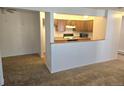Kitchen with light wood cabinets and a pass-through to the dining area at 14794 E 2Nd Ave # 111F, Aurora, CO 80011