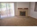 Living room with fireplace and sliding glass door leading to a patio at 14794 E 2Nd Ave # 111F, Aurora, CO 80011