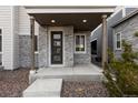 Covered front porch with stone facade and a modern door at 23630 E 5Th Pl, Aurora, CO 80018