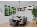 Dining room with a modern light fixture, large window, and hardwood floors at 3916 N Raleigh St, Denver, CO 80212