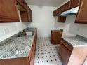 Compact kitchen featuring granite countertops and ample cabinetry at 10772 E Exposition Ave # 140, Aurora, CO 80012