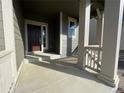 Covered front porch with dark brown door and columns at 5571 Wisteria Avenue, Firestone, CO 80107