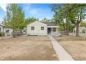 Light yellow house with navy blue door and small front porch at 1300 Wabash St, Denver, CO 80220