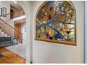 Elegant entryway with stained glass window and hardwood floors at 2891 Canyon Crest Dr, Highlands Ranch, CO 80126