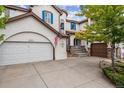 Two-story house with white exterior, blue shutters, and a two-car garage at 2891 Canyon Crest Dr, Highlands Ranch, CO 80126