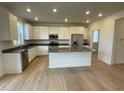 Modern kitchen with stainless steel appliances and an island at 5571 Wisteria Ave, Firestone, CO 80504