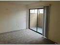 Living room with carpet flooring and sliding doors to a patio at 10782 E Exposition Ave # 148, Aurora, CO 80012