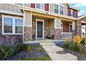 Front porch with stone facade, dark door, and wicker seating at 6251 N Malaya St, Aurora, CO 80019