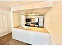 Kitchen with a breakfast bar, modern appliances, and tile countertops at 16001 E Alaska Pl # 7, Aurora, CO 80017