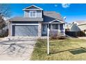 Two-story house with gray siding, two-car garage, and a landscaped front yard with a for sale sign at 4391 S Fundy St, Centennial, CO 80015