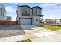 Two-story house with gray siding and two-car garage at 13502 E 100Th Ave, Commerce City, CO 80022