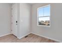 Bright entryway with wood-look floors, neutral walls, and a view from a large window at 13502 E 100Th Ave, Commerce City, CO 80022