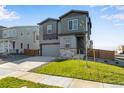 Two-story house with gray siding and two-car garage at 13502 E 100Th Ave, Commerce City, CO 80022