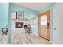 Inviting entryway with fireplace, wood floors and light blue walls at 6860 Surrey Trl, Littleton, CO 80125