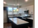 Modern kitchen with white cabinets, quartz countertops, and geometric backsplash at 5780 Taft Trl, Arvada, CO 80002