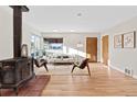 Living room with hardwood floors, wood burning stove, and large windows at 4482 E Utah Pl, Denver, CO 80222