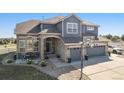 Two-story house with stone and gray siding, three-car garage, and basketball hoop at 9508 E 147Th Ave, Brighton, CO 80602