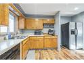 Kitchen features wood cabinets, stainless steel appliances, and wood-look flooring at 13413 W 21St Ave, Golden, CO 80401