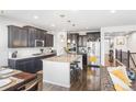 Modern kitchen with dark cabinets, granite counters, and an island at 15373 E 113Th Pl, Commerce City, CO 80022
