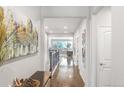 Bright hallway with hardwood floors and views to the living room at 15373 E 113Th Pl, Commerce City, CO 80022