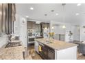Modern kitchen with dark cabinets, granite counters, and an island at 15373 E 113Th Pl, Commerce City, CO 80022