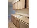 Bright kitchen with light wood cabinets and tile flooring at 7755 E Quincy Ave # 101, Denver, CO 80237