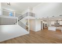Open concept main level with kitchen, stairs to upper level, and hardwood floors at 42980 Colonial Trl, Elizabeth, CO 80107