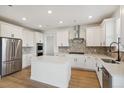 Spacious kitchen featuring white cabinets, herringbone backsplash, and large island at 42980 Colonial Trl, Elizabeth, CO 80107