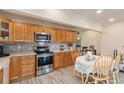 Modern kitchen with wood cabinets, stainless steel appliances, and a breakfast nook at 4545 Raritan St, Denver, CO 80211