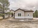 House exterior featuring stucco siding, dark roof, and landscaping at 11063 Sheffield Ct, Parker, CO 80134