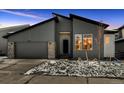 Modern two-story home with gray siding, a two-car garage, and a landscaped front yard at 573 Coal Bank Trl, Castle Rock, CO 80104