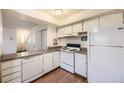 Galley kitchen with white appliances and granite countertops at 2604 S Xanadu Way # B, Aurora, CO 80014