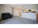 Living room with a black leather couch, looking toward kitchen and dining area at 15157 E Louisiana Dr # D, Aurora, CO 80012