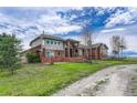 Brick house with large windows and a paved driveway at 1820 S State Highway 83, Franktown, CO 80116
