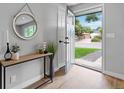 Bright entryway with wood floors, console table, and round mirror at 7946 Joan Dr, Denver, CO 80221
