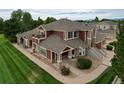 Two-story home with red exterior, landscaping, and walkway, aerial view at 13722 Legend Way # 101, Broomfield, CO 80023