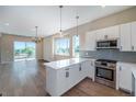 Modern kitchen with white cabinets, stainless steel appliances, and quartz countertops at 8500 W 62Nd Ave # H, Arvada, CO 80004