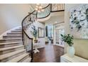 Grand entryway with curved staircase and hardwood floors at 6664 Serena Ave, Castle Pines, CO 80108