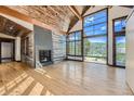 Open living room with hardwood floors, fireplace, and large windows at 964 Alpensee Dr, Breckenridge, CO 80424