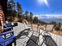 Deck with seating area and fire pit overlooking mountain views at 13640 Old Paint Trl, Conifer, CO 80433