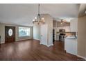 Open concept living and kitchen area with laminate flooring and a chandelier at 8465 Wheatgrass Cir, Parker, CO 80134