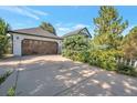 Attached garage with a wooden door and a spacious driveway at 8465 Wheatgrass Cir, Parker, CO 80134