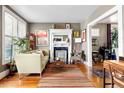 Bright living room featuring hardwood floors, a fireplace, and ample natural light at 34 W Maple Ave, Denver, CO 80223