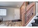 Modern entryway with exposed brick accent wall and hardwood floors at 4197 Deer Watch Dr, Castle Rock, CO 80104